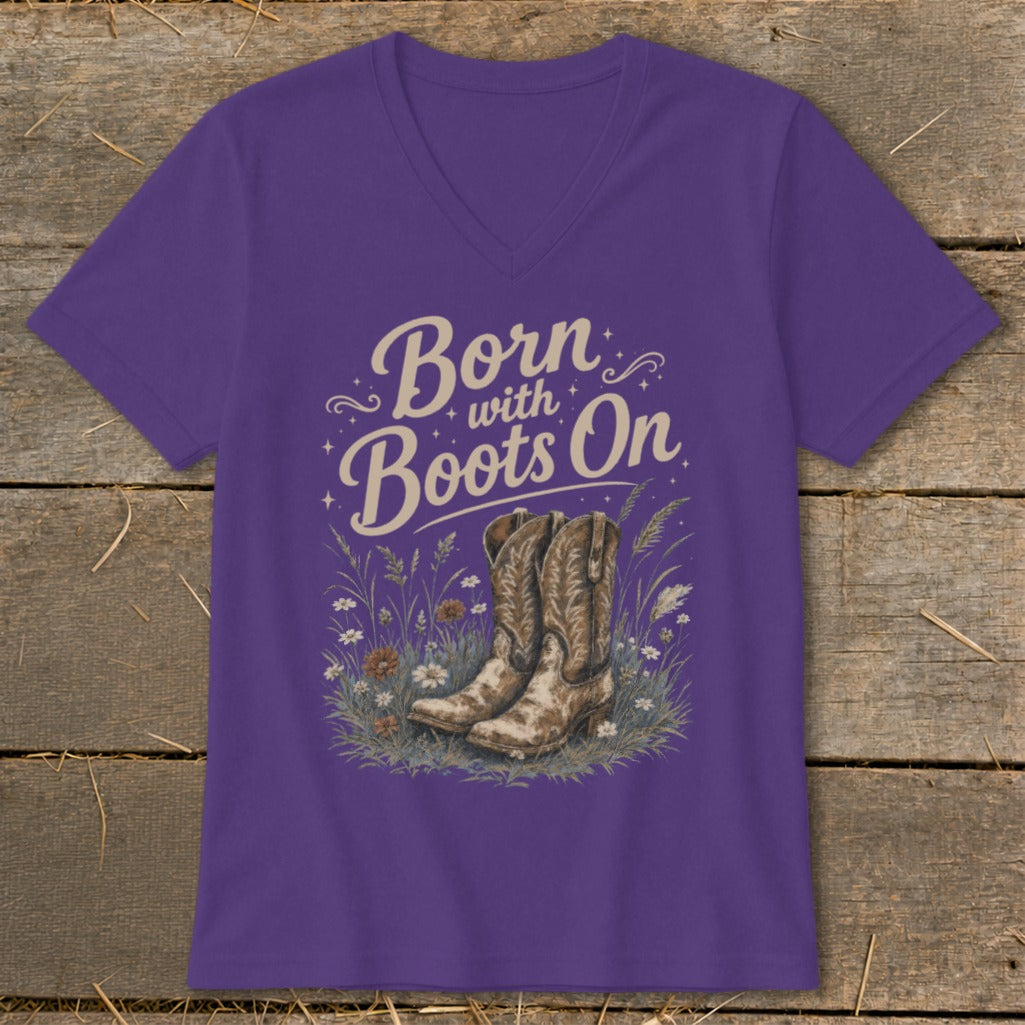 Purple t-shirt with "Born with Boots On" text and cowboy boots in a floral field.
