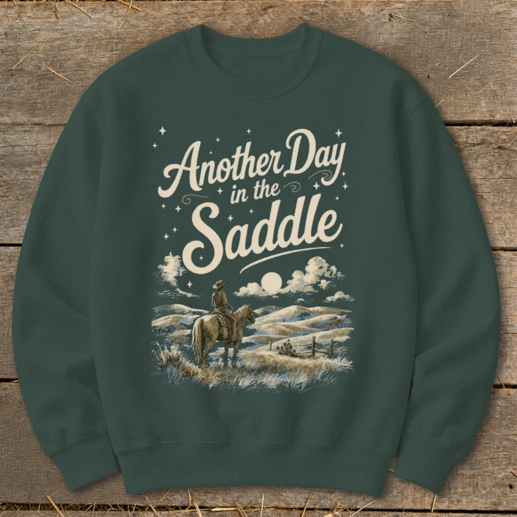 Sweatshirt with "Another Day in the Saddle" text and cowboy on horseback.