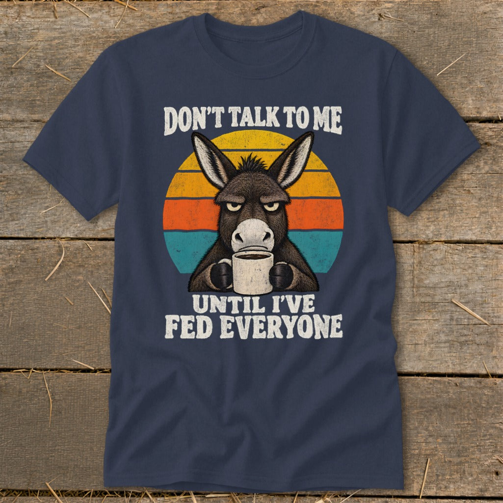 Navy blue t-shirt featuring a grumpy donkey holding a coffee mug, with retro sunset stripes and text.