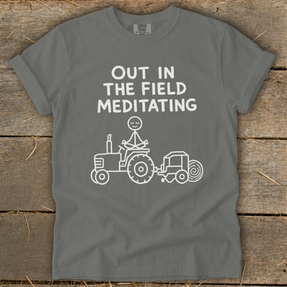 White graphic of a figure meditating on a tractor with text "Out in the field meditating".