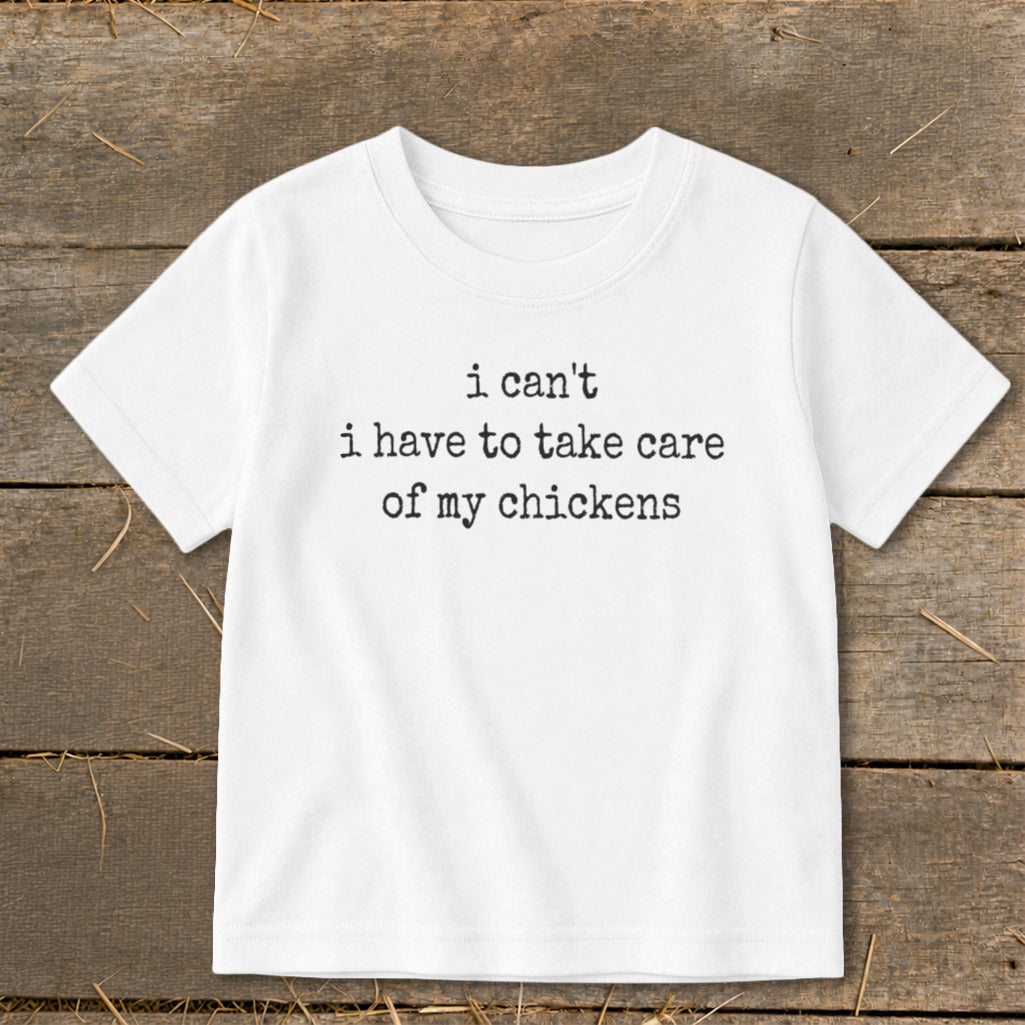 White t-shirt with "i can't i have to take care of my chickens" text.