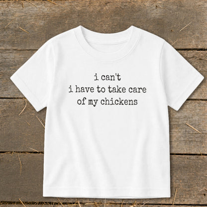 White t-shirt with "i can't i have to take care of my chickens" text.