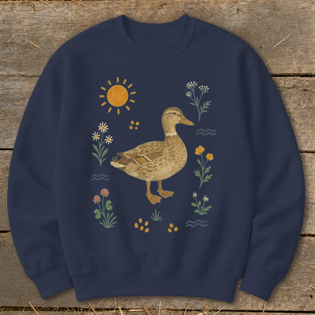 Navy sweatshirt with a watercolor-style duck surrounded by flowers and sun.