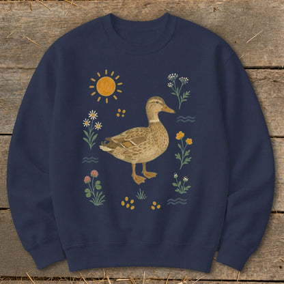 Navy sweatshirt with a watercolor-style duck surrounded by flowers and sun.