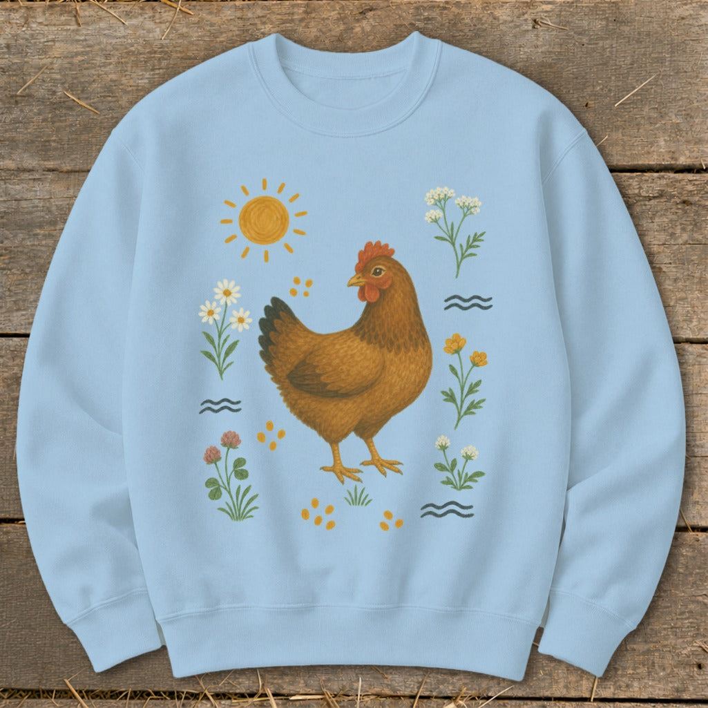 Light blue sweatshirt with a brown hen, sun, and floral illustrations.