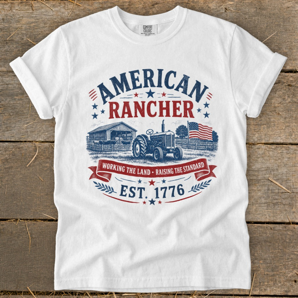 White t-shirt with "American Rancher" graphic featuring a barn, tractor, and American flag.