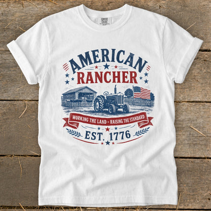 White t-shirt with "American Rancher" graphic featuring a barn, tractor, and American flag.