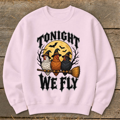 Three chickens wearing witch hats ride a broomstick under a full moon with text "TONIGHT WE FLY".
