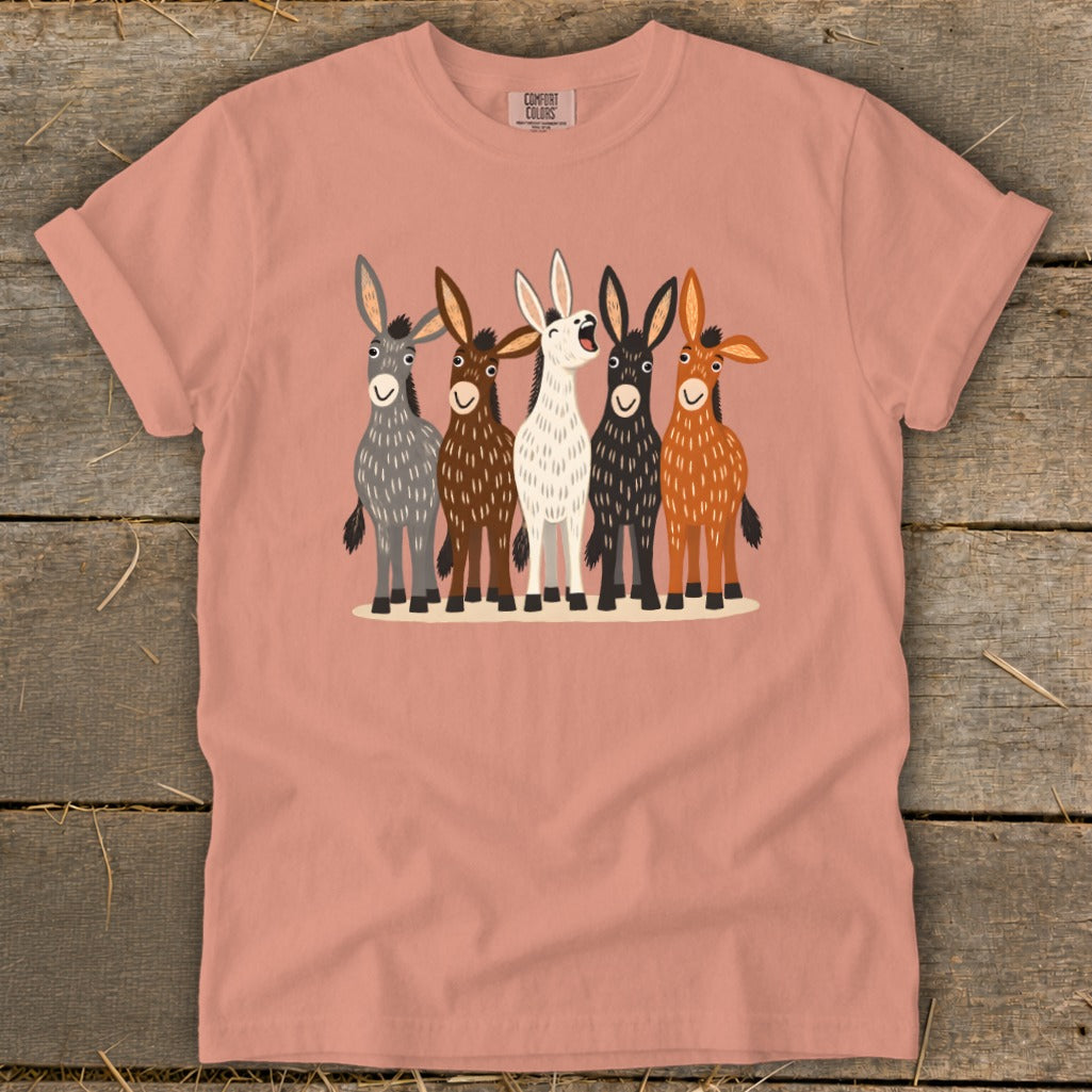 A peach-colored crewneck t-shirt featuring a front graphic of five colorful, illustrated donkeys standing together.