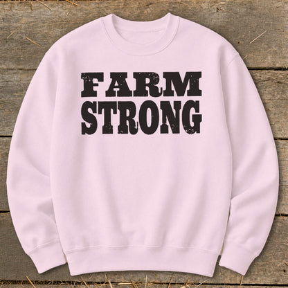 A light pink crewneck sweatshirt featuring the black distressed text FARM STRONG across the chest.