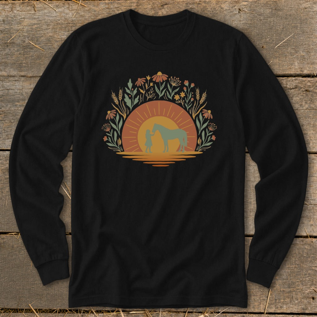 Black long-sleeve shirt with a circular floral design featuring a child and horse silhouetted against a sunset.