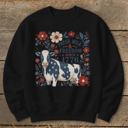 Cow with American flag pattern on black sweatshirt with "Fresh Milk & Freedom Since 1776" text.