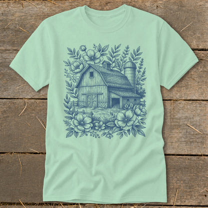Barn and silo surrounded by floral illustrations on a mint green t-shirt.