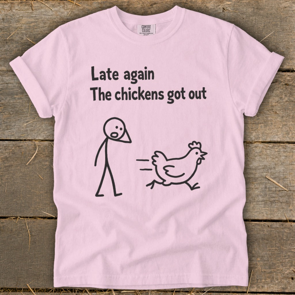Pink t-shirt with text "Late again The chickens got out" and cartoon drawings.