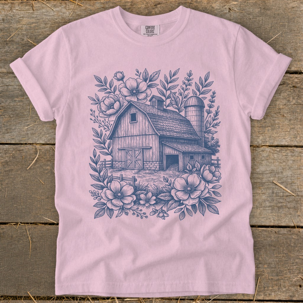 Pink t-shirt with a blue sketch of a barn, silo, and flowers.