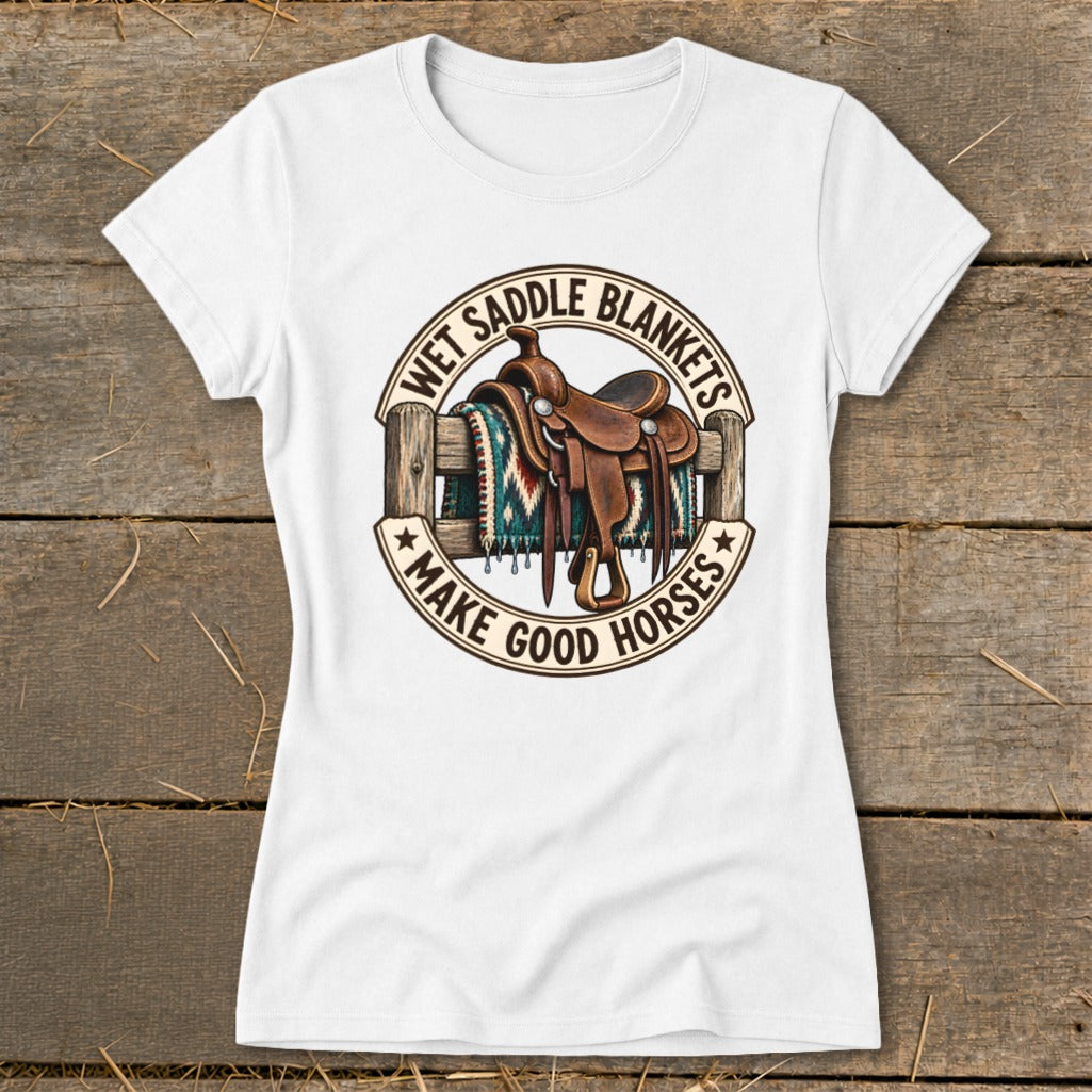 White t-shirt with graphic of saddle and blanket over fence, text "Wet Saddle Blankets Make Good Horses".