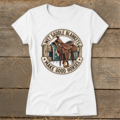 White t-shirt with graphic of saddle and blanket over fence, text "Wet Saddle Blankets Make Good Horses".