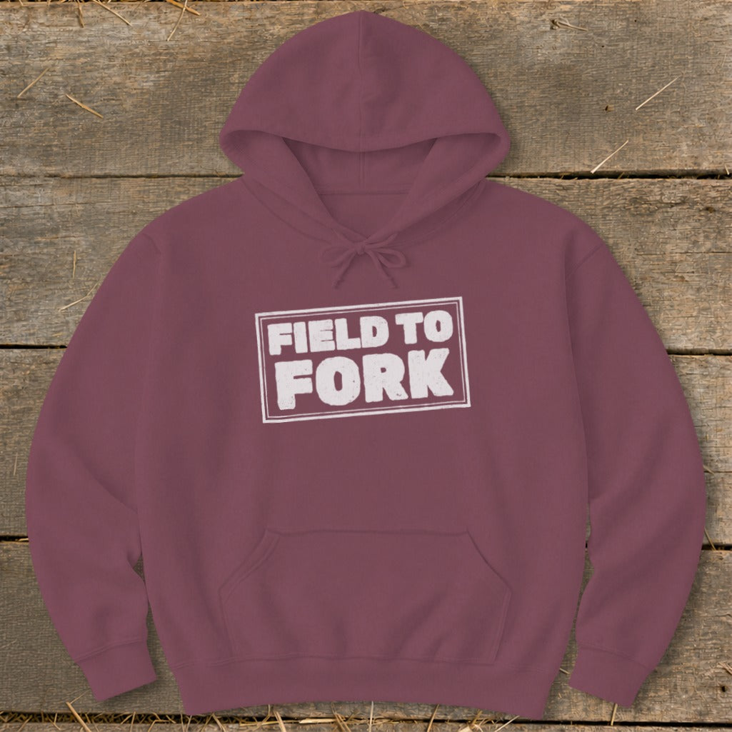 A maroon pullover hoodie features a white boxed graphic with the text FIELD TO FORK.