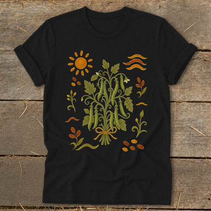 Black t-shirt with a botanical illustration of a pea plant, sun, and abstract motifs.