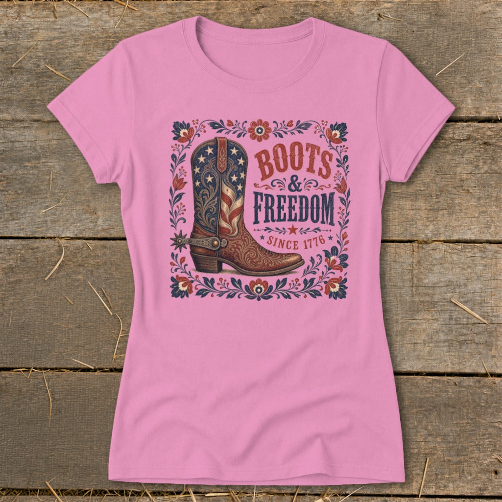 Pink t-shirt with a graphic of a cowboy boot, "Boots & Freedom," and "Since 1776."