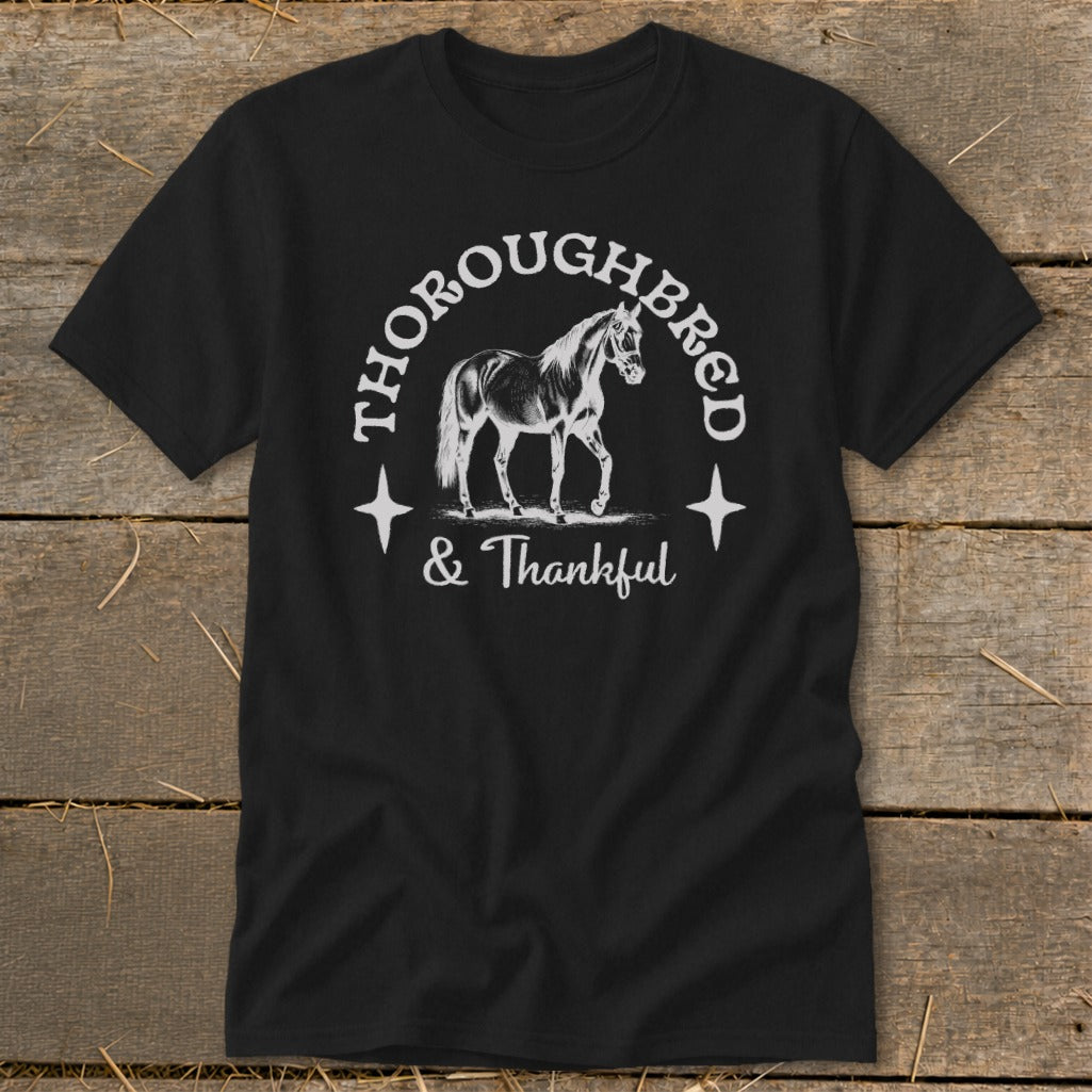 Black t-shirt with a white graphic of a horse and text "THOROUGHBRED & Thankful".