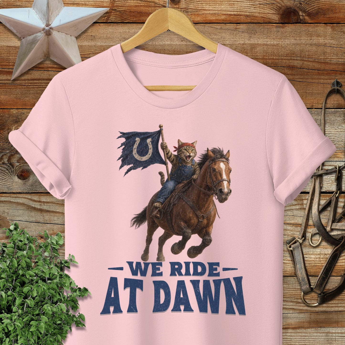 Cat in cowboy hat riding horse with "We Ride At Dawn" text.