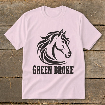 A light pink t-shirt with a black graphic of a horse's head and the text "GREEN BROKE" underneath.