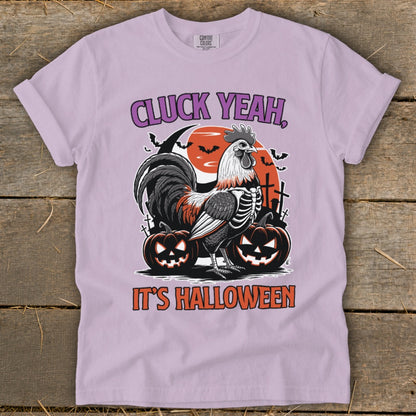 Light purple t-shirt with skeleton rooster, pumpkins, and "CLUCK YEAH, IT'S HALLOWEEN" text.