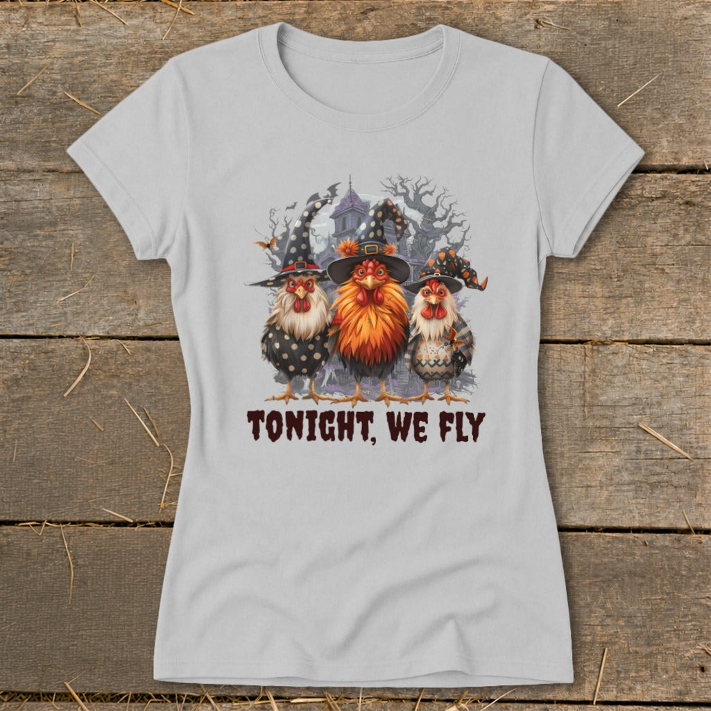 Three chickens in witch hats stand in front of a spooky house. Text reads "TONIGHT, WE FLY."
