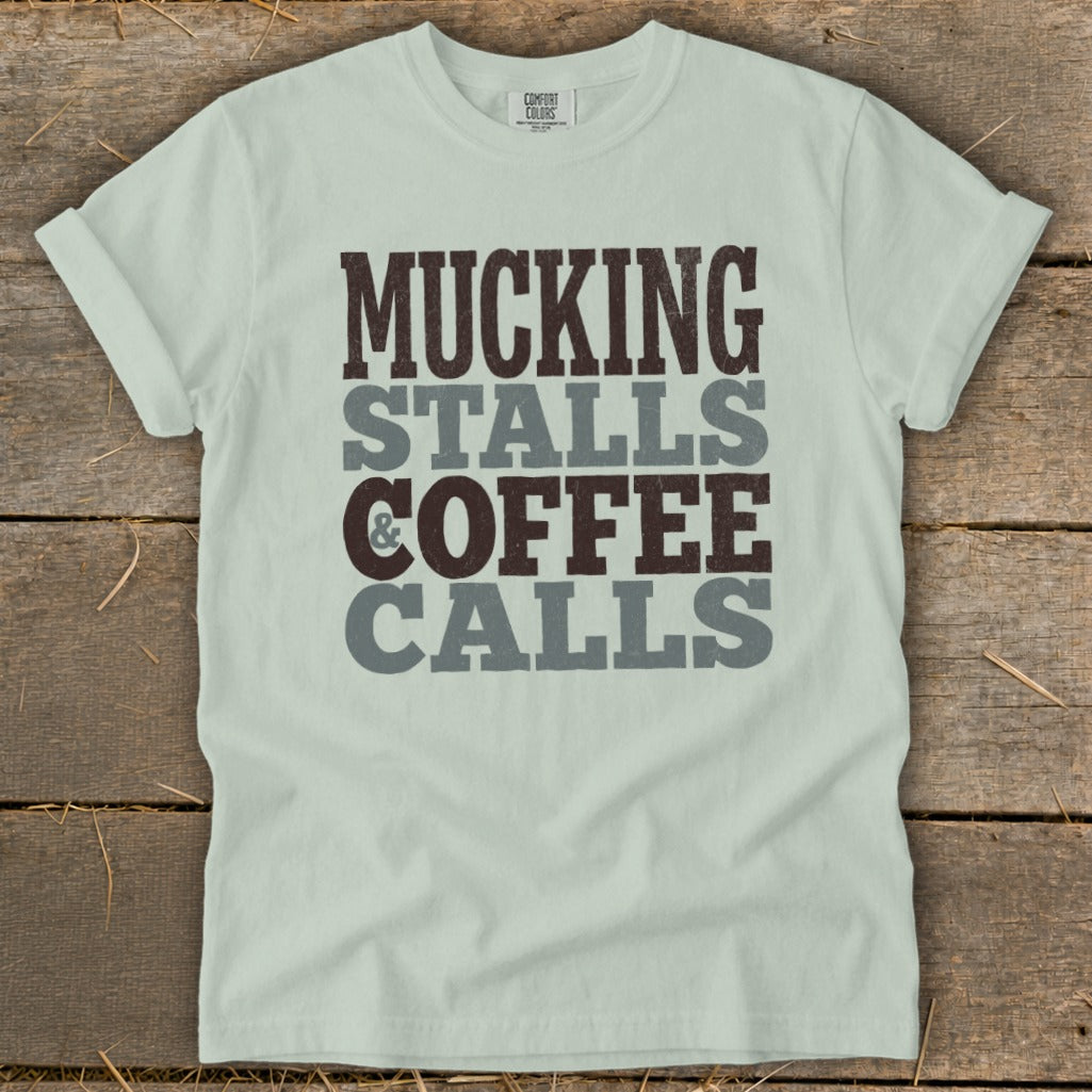 Light blue t-shirt with text "Mucking Stalls & Coffee Calls".