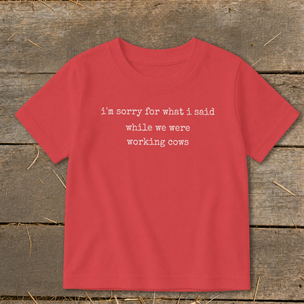 Red t-shirt with white text reading "i'm sorry for what i said while we were working cows".