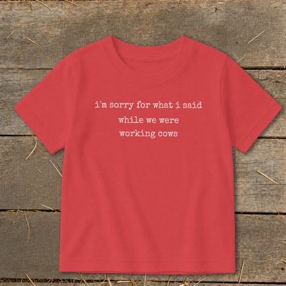 Red t-shirt with white text reading "i'm sorry for what i said while we were working cows".