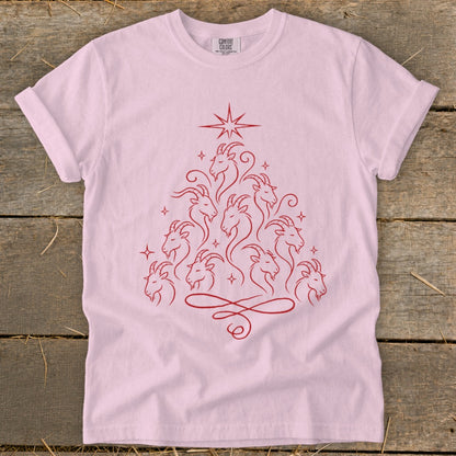 Pink t-shirt with a red line art design of goats forming a Christmas tree shape.