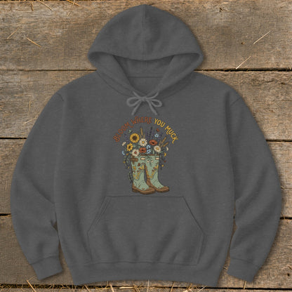 Dark gray hoodie with a graphic of rain boots filled with flowers and the text "Bloom Where You Muck."