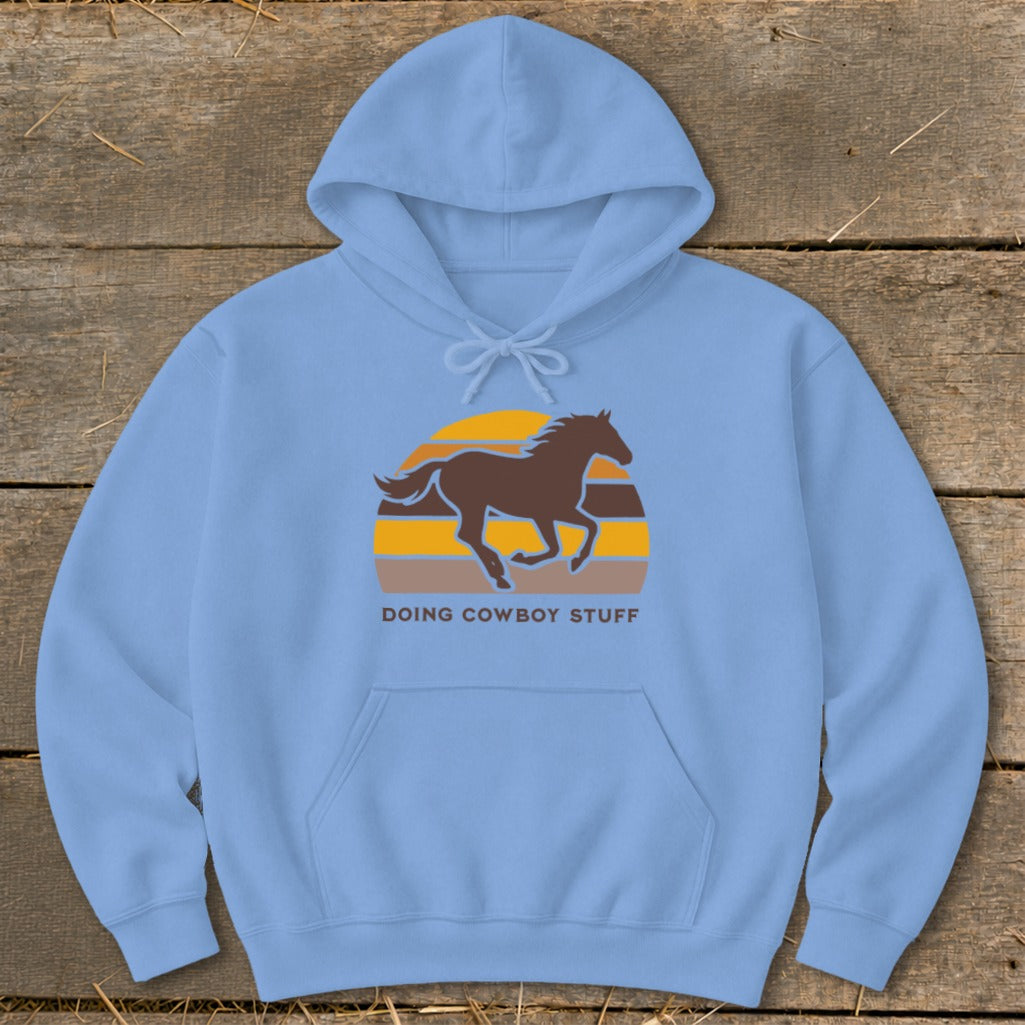Light blue hoodie with a brown horse silhouette over a retro sunset graphic and text.