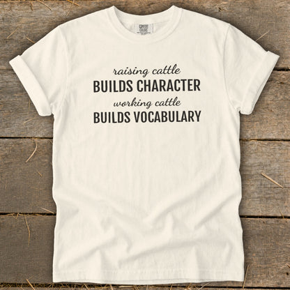 White t-shirt with text: Raising cattle builds character, working cattle builds vocabulary.