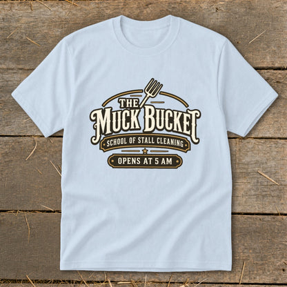 Light blue t-shirt with "The Muck Bucket School of Stall Cleaning" logo.