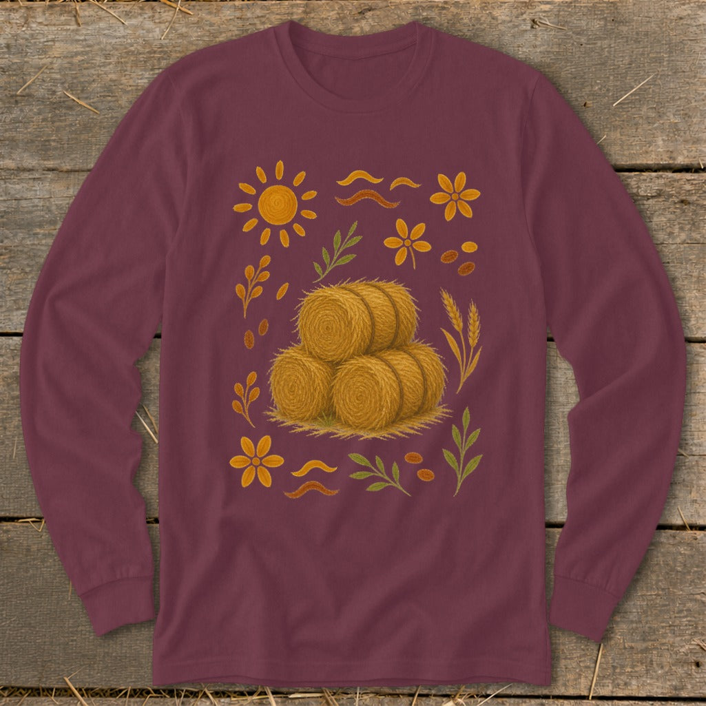 Burgundy long-sleeve shirt with a central stack of hay bales surrounded by autumn motifs.