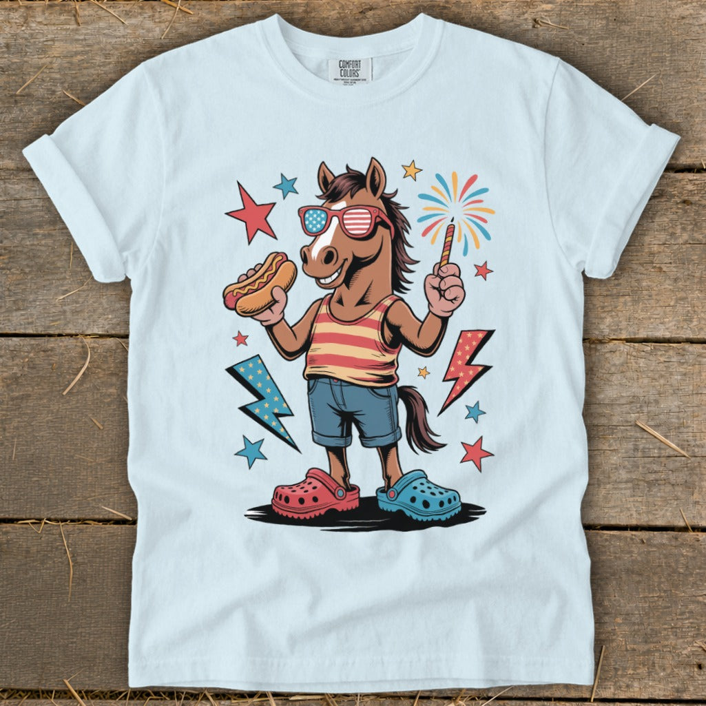 Cartoon horse wearing American flag sunglasses, holding a hot dog and sparkler, with fireworks.