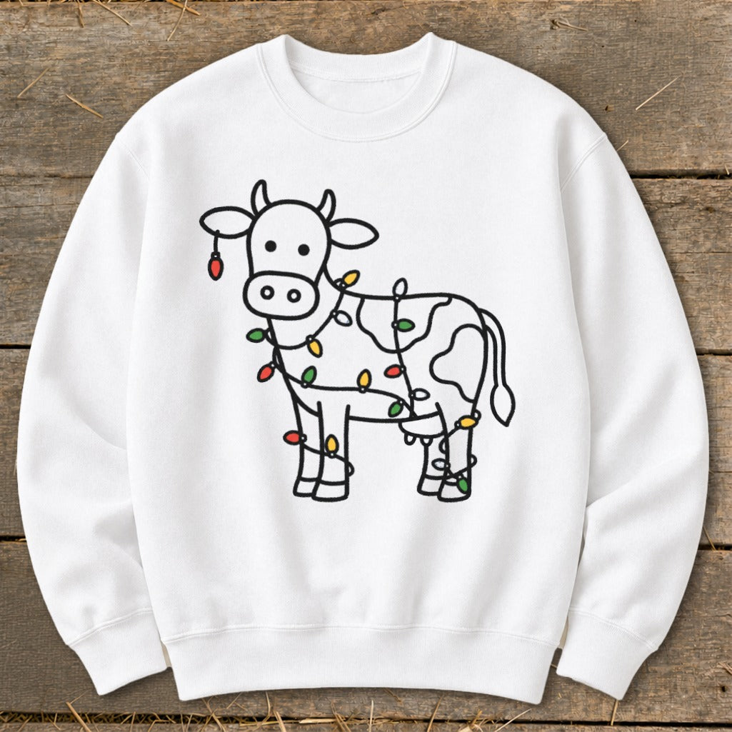 White sweatshirt with a black outline illustration of a cow wrapped in colorful Christmas lights.