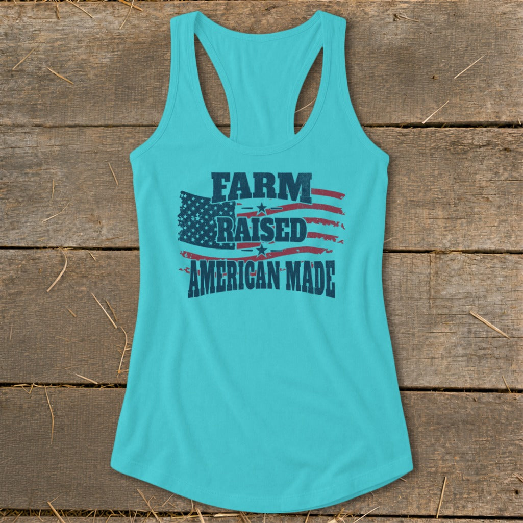 Teal racerback tank top with distressed American flag and text "FARM RAISED AMERICAN MADE".