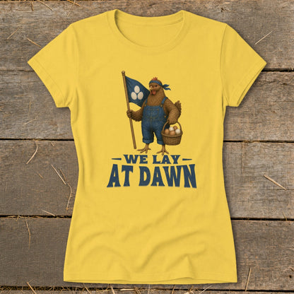 Yellow t-shirt with a chicken in overalls holding a flag and basket of eggs, text reads "We Lay At Dawn".