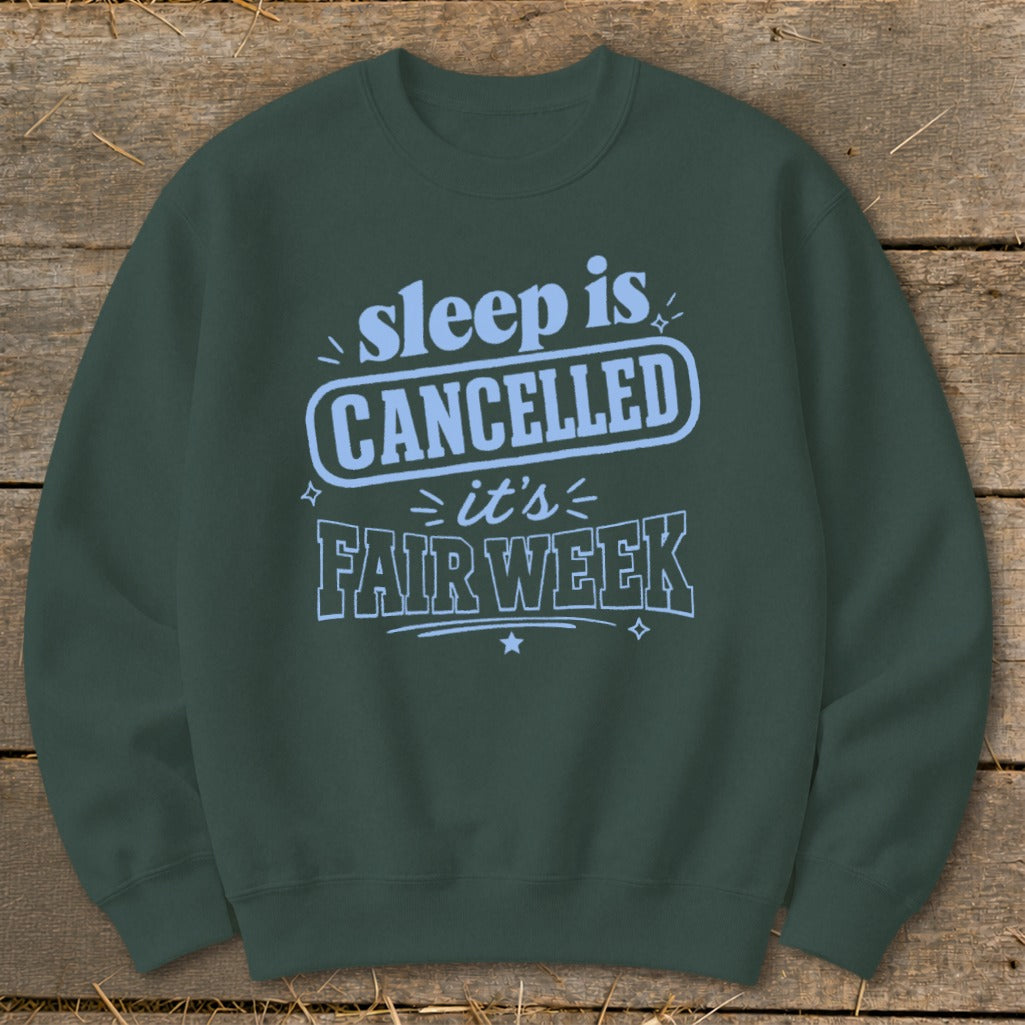 Dark green sweatshirt with light blue text "sleep is CANCELLED it's FAIR WEEK".