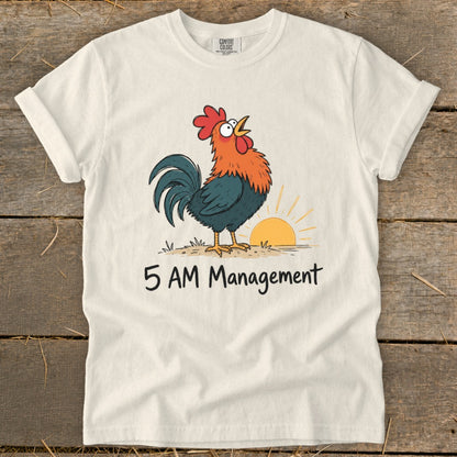 White t-shirt with cartoon rooster at sunrise and "5 AM Management" text.