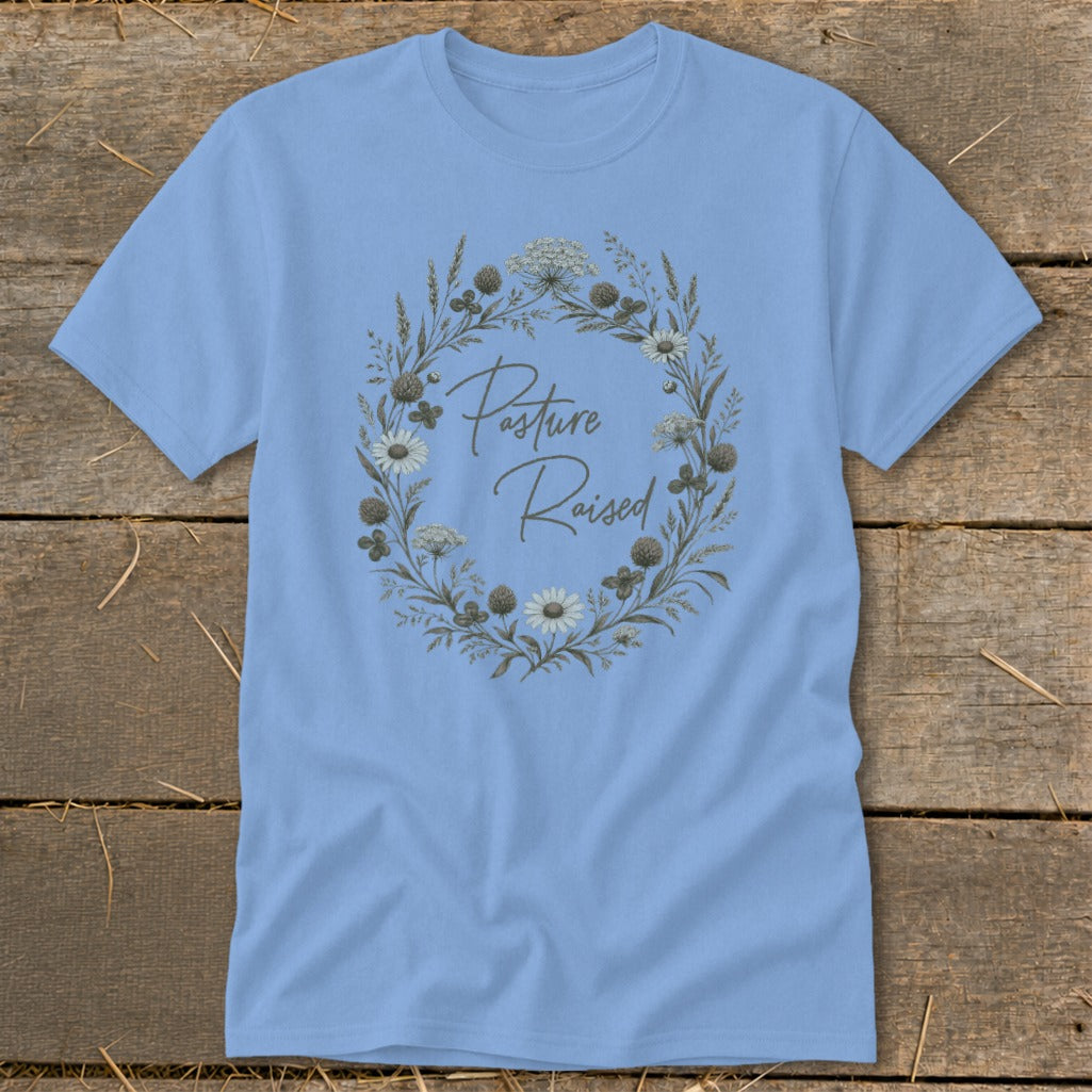 Light blue t-shirt with "Pasture Raised" in script inside a floral wreath design.