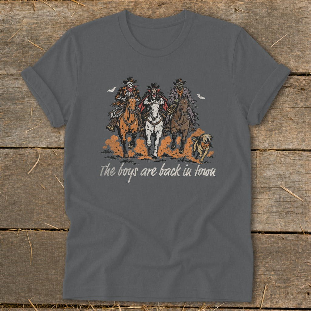 Dark grey t-shirt with three skeleton cowboys and a dog riding horses, text reads "The boys are back in town".