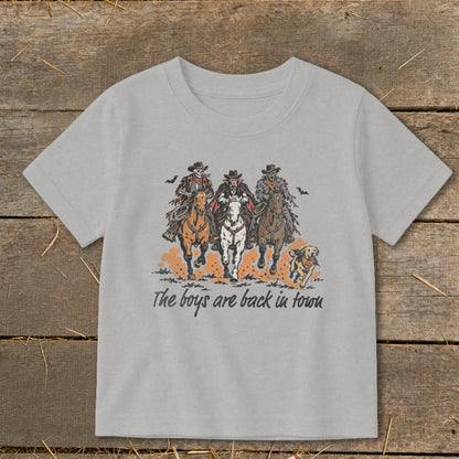 Light gray t-shirt graphic: skeleton, vampire, zombie cowboys ride horses, with a dog and text "The boys are back in town".