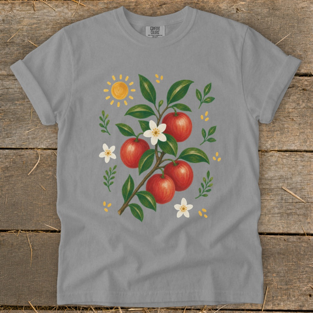 Gray t-shirt with a watercolor illustration of a branch with red apples, white flowers, and a sun.