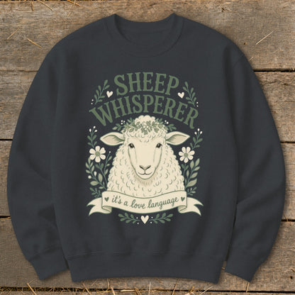 Sheep Whisperer text and sheep graphic with wreath on dark gray sweatshirt.
