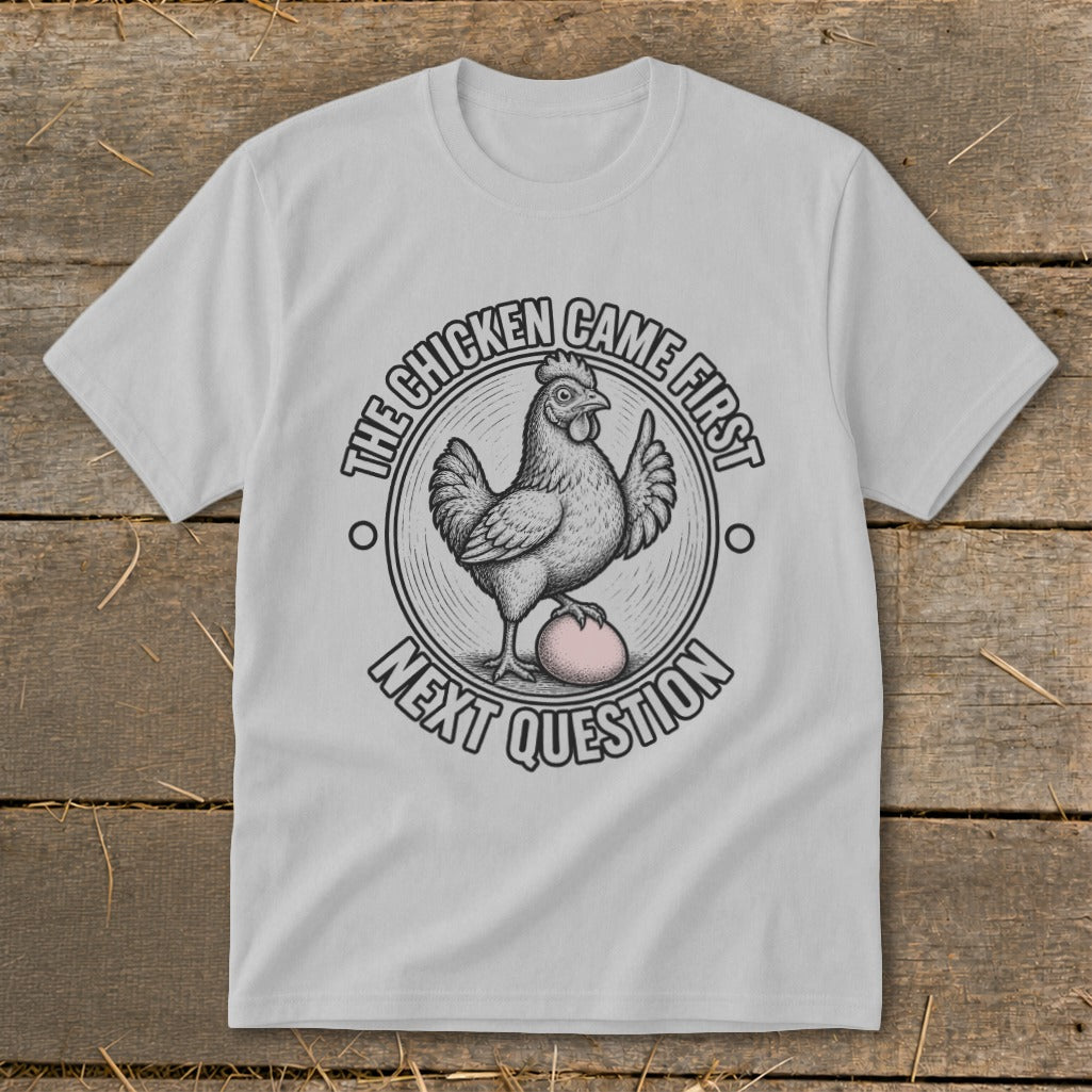 T-shirt graphic with chicken on egg, text "The chicken came first, next question".